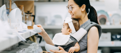 Woman shopping for dishes with her baby